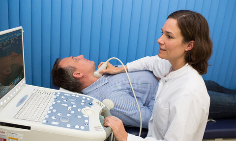 Ärztin behandelt einen Patienten mit Ultraschall